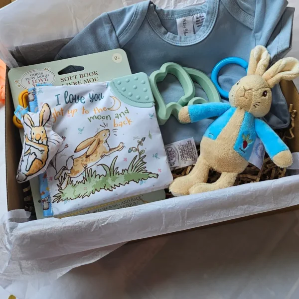 Luxury baby gift box Australia featuring Peter Rabbit toys and organic-feel blue newborn essentials.