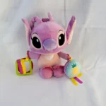 Plush Disney Baby Angel activity toy for infants, featuring a soft purple character doll with hanging plastic teething rings and a round plush pineapple rattle disc with satin tags.